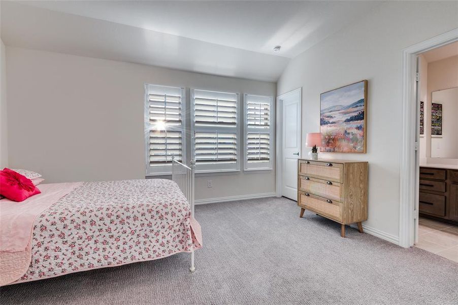 Bedroom with lofted ceiling and light carpet