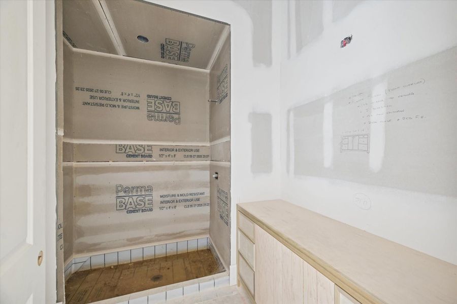 This angle highlights the framed shower or tub enclosure along with linen storage space. Plumbing and wall prep are in place for the selected tile package and final finishes. A practical bath layout built for comfort and long-term durability.