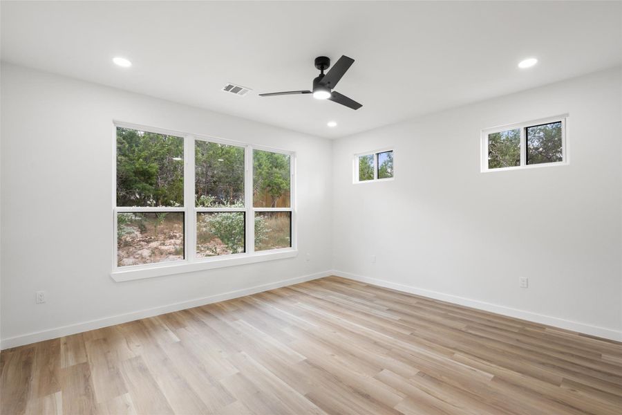 Unfurnished room featuring healthy amount of natural light, light wood-style flooring, recessed lighting, and a ceiling fan Unfurnished room featuring healthy amount of natural light, light wood-style flooring, recessed lighting, and a ceiling fan