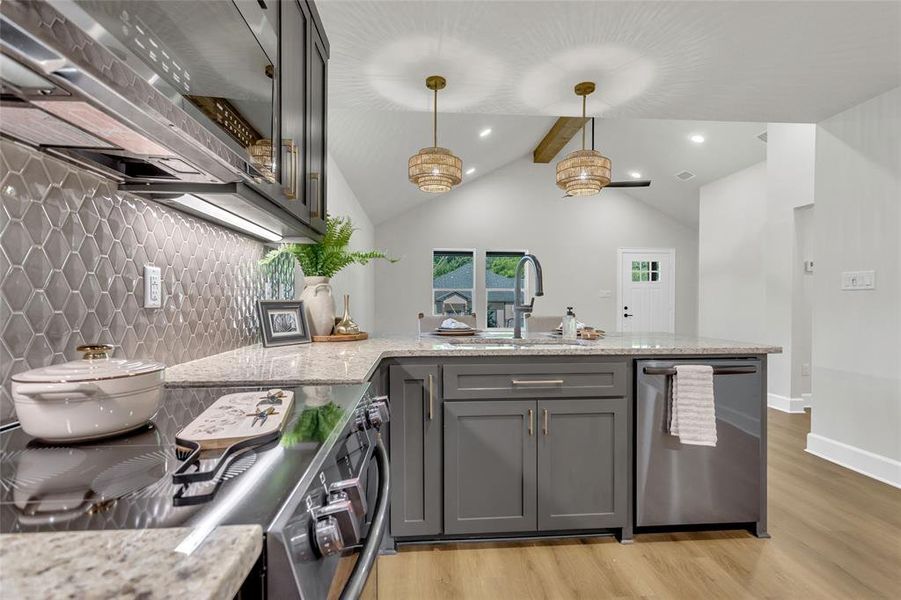 Kitchen with range with gas stovetop, decorative backsplash, ventilation hood, dishwasher, and a peninsula Kitchen with range with gas stovetop, decorative backsplash, ventilation hood, dishwasher, and a peninsula