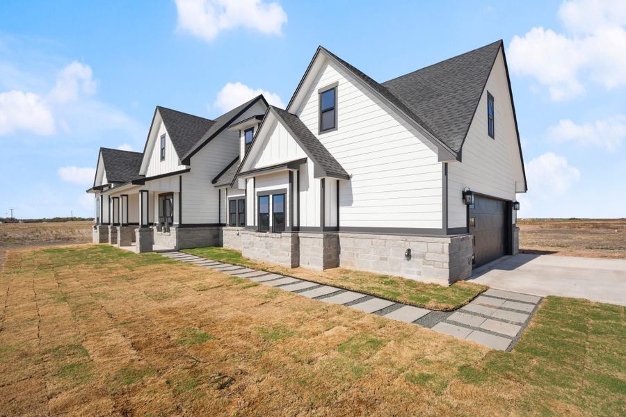 A striking modern farmhouse showcases clean lines, contrasting trim, and a welcoming covered porch. A striking modern farmhouse showcases clean lines, contrasting trim, and a welcoming covered porch.