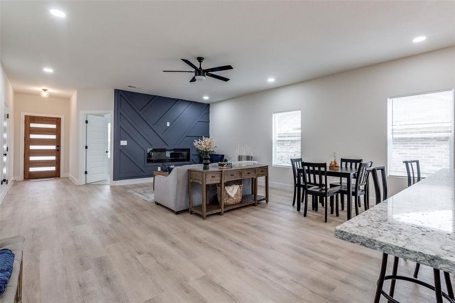 Living room with a healthy amount of sunlight, ceiling fan, and light hardwood / wood-style floors