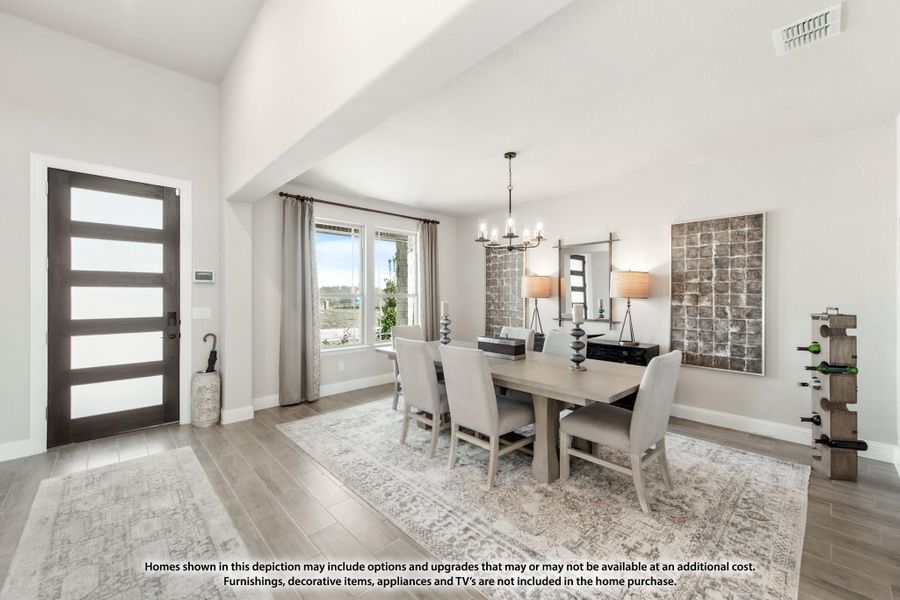 Dining room with high ceilings, chandelier, gray dining table and chairs, and hardwood floors near front entry door Dining room with high ceilings, chandelier, gray dining table and chairs, and hardwood floors near front entry door