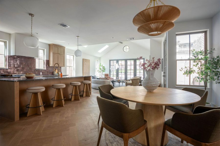 Fine herringbone wood floors sweep through the open dining and kitchen areas. Fine herringbone wood floors sweep through the open dining and kitchen areas.