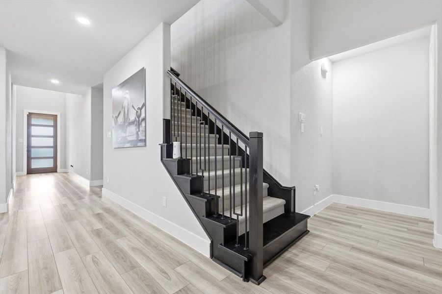 Stairway featuring wood finished floors and recessed lighting