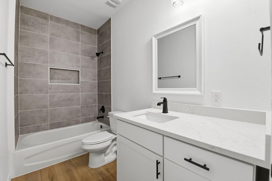 Full secondary bathroom with modern finishes and tile walls