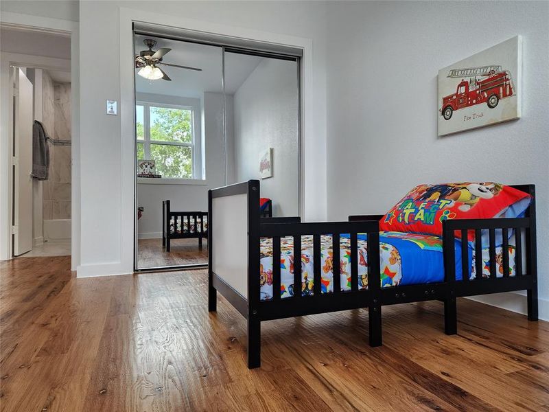 Bedroom with ceiling fan, hardwood / wood-style flooring, and a closet