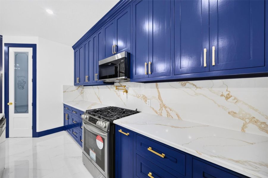 Kitchen view highlighting bold cabinetry, sleek backsplash and generous counter space