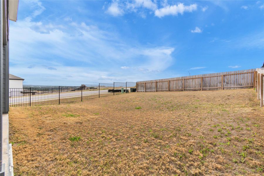 A spacious backyard awaits, featuring a privacy fence and scenic distant views.
