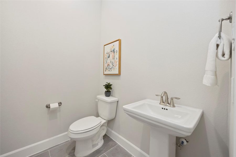 A downstairs retreat featuring a timeless pedestal sink, offering both style and convenience.
