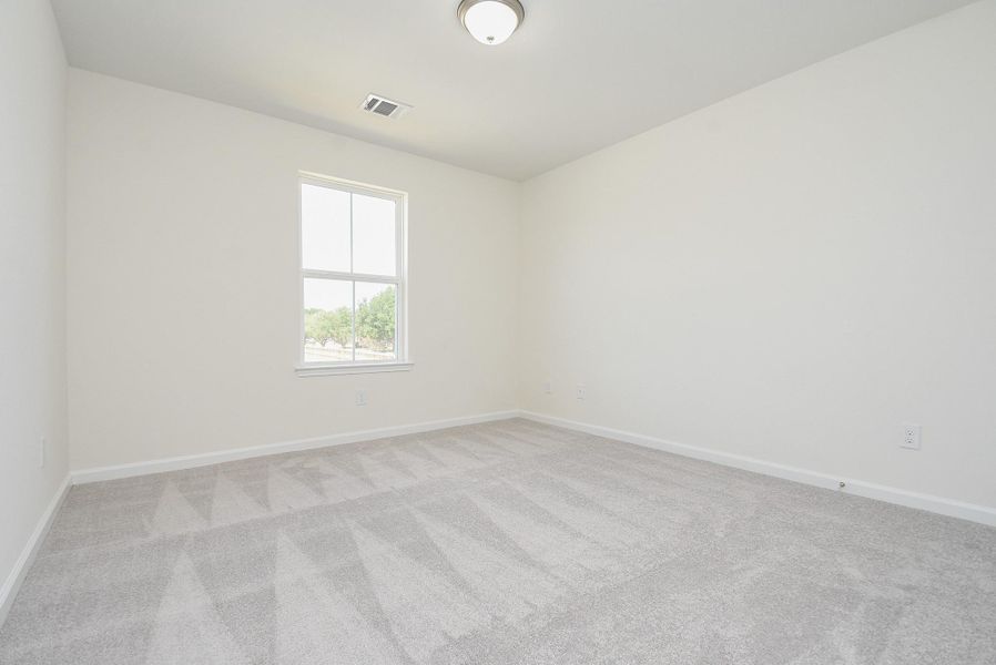 Empty room with beige walls, carpeted floor, one window, and a recessed ceiling light. Empty room with beige walls, carpeted floor, one window, and a recessed ceiling light.