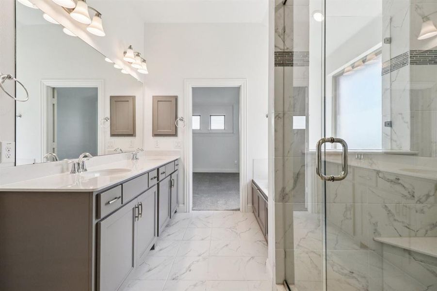 Full bathroom with double vanity, a marble finish shower, and light marble finish flooring Full bathroom with double vanity, a marble finish shower, and light marble finish flooring