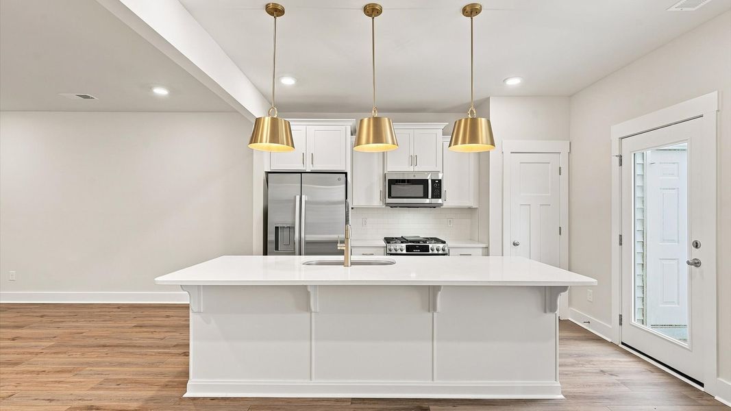 Vibrant kitchen layout with a center island, refined finishes, and open-concept flow at Ransdell Pointe Vibrant kitchen layout with a center island, refined finishes, and open-concept flow at Ransdell Pointe