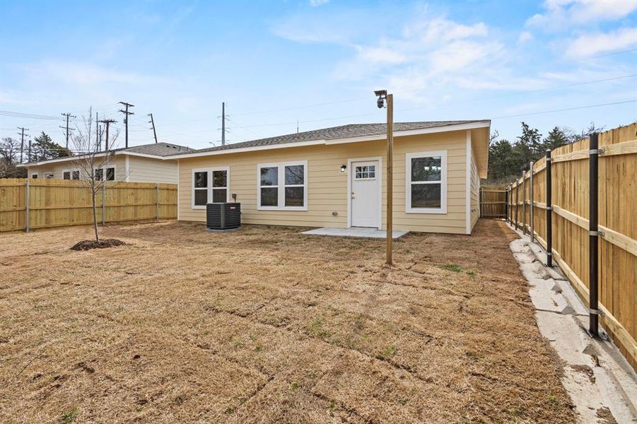 Back of house with a patio, a fenced backyard, and central air condition unit