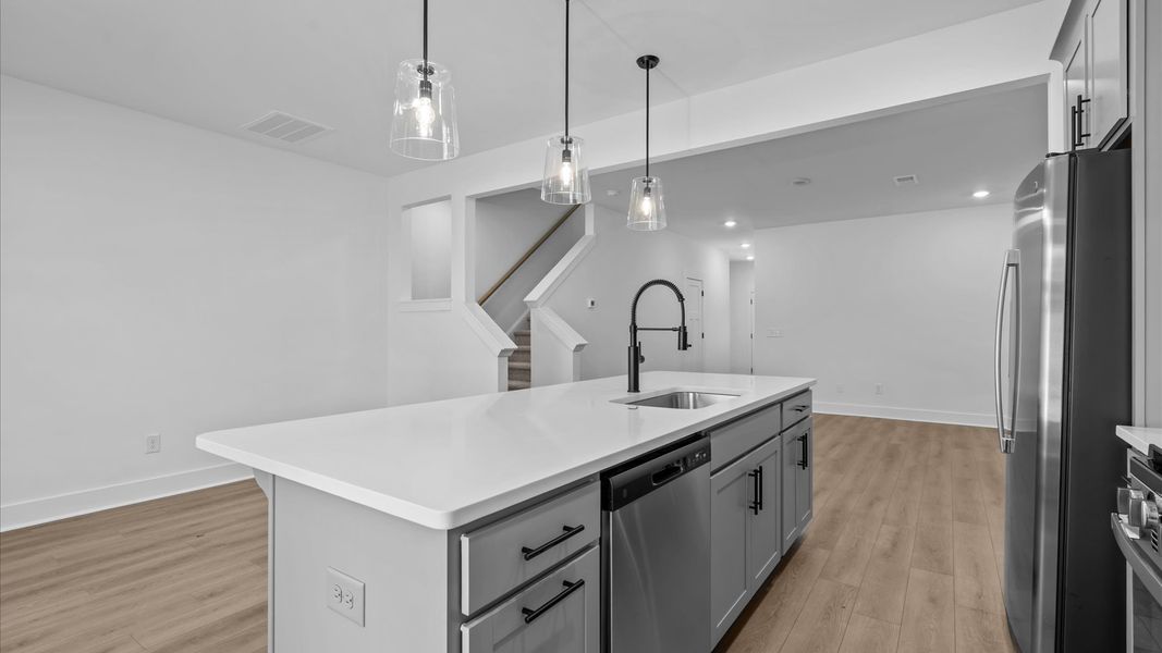 First-class kitchen with a spacious 9-foot island perfect for entertaining beneath designer pendant lighting