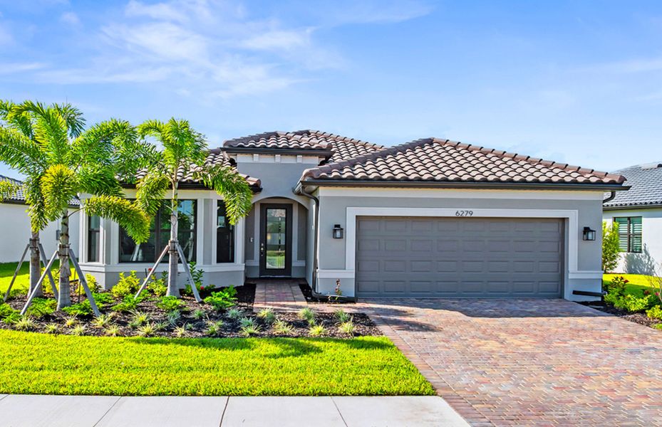 Front exterior of a new home in Del Webb Naples, Immokalee, FL, highlighting curb appeal (Image 1).