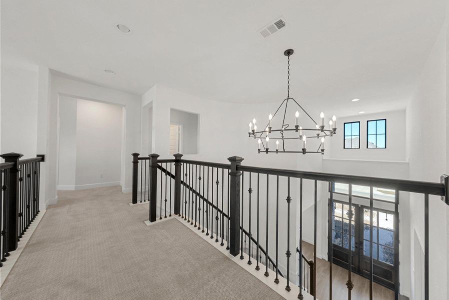 Hall featuring recessed lighting, a notable chandelier, carpet floors, visible vents, and an upstairs landing