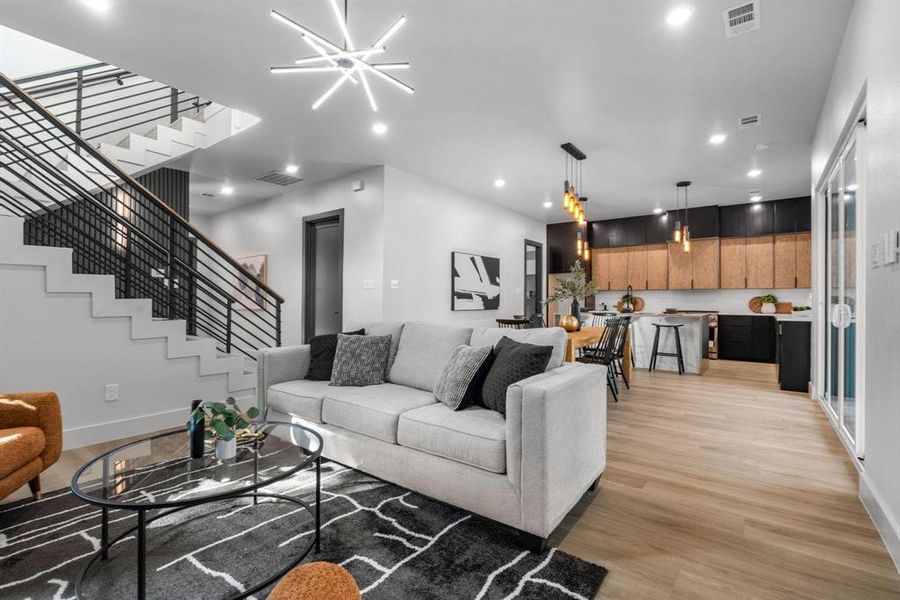 Living area featuring light wood-style floors, recessed lighting, and stairs