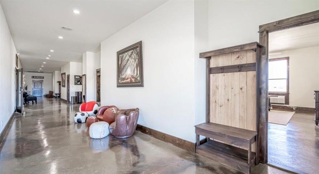 Hallway featuring concrete flooring, baseboards, visible vents, and recessed lighting Hallway featuring concrete flooring, baseboards, visible vents, and recessed lighting