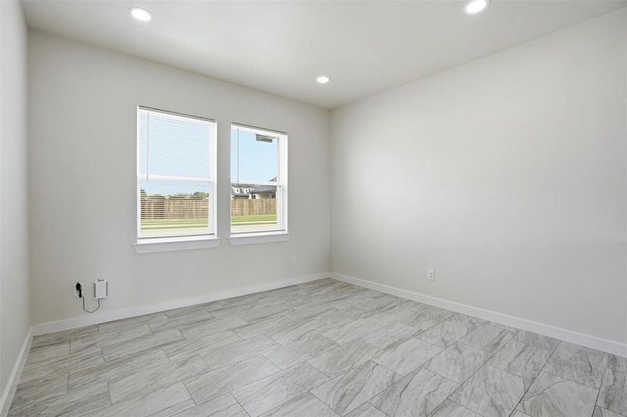 Room featuring two windows with blinds, recessed lighting, and light-toned tile flooring
