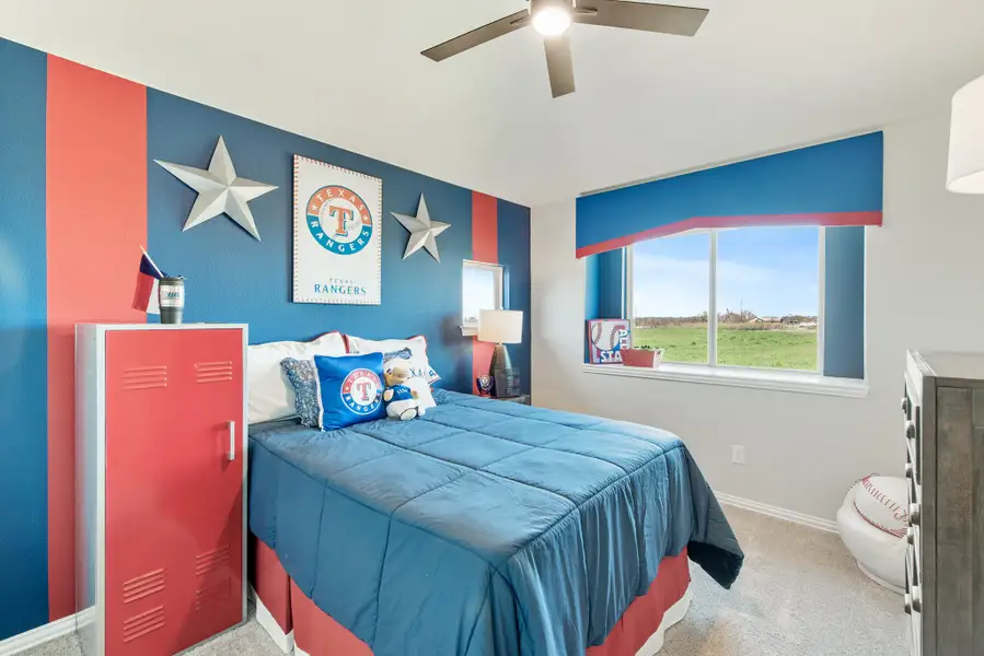 Kids bedroom with Texas Rangers themed decor, blue and red striped walls, and ceiling fan