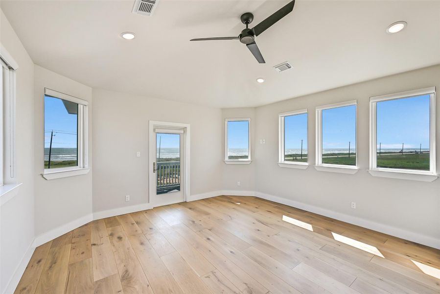 Expansive windows flood the primary suite with natural light while framing beautiful coastal scenery. The generous layout creates a true owner’s retreat designed for rest and relaxation.