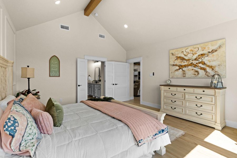 Bedroom featuring beamed ceiling, light wood-style floors, high vaulted ceiling, recessed lighting, and ensuite bathroom Bedroom featuring beamed ceiling, light wood-style floors, high vaulted ceiling, recessed lighting, and ensuite bathroom