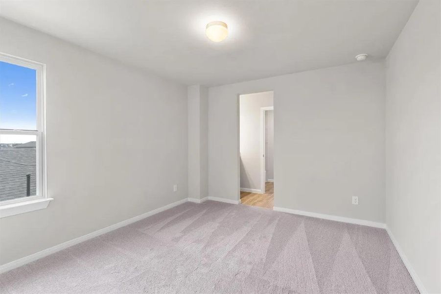 A well-proportioned bedroom offers fresh carpet and abundant natural light.