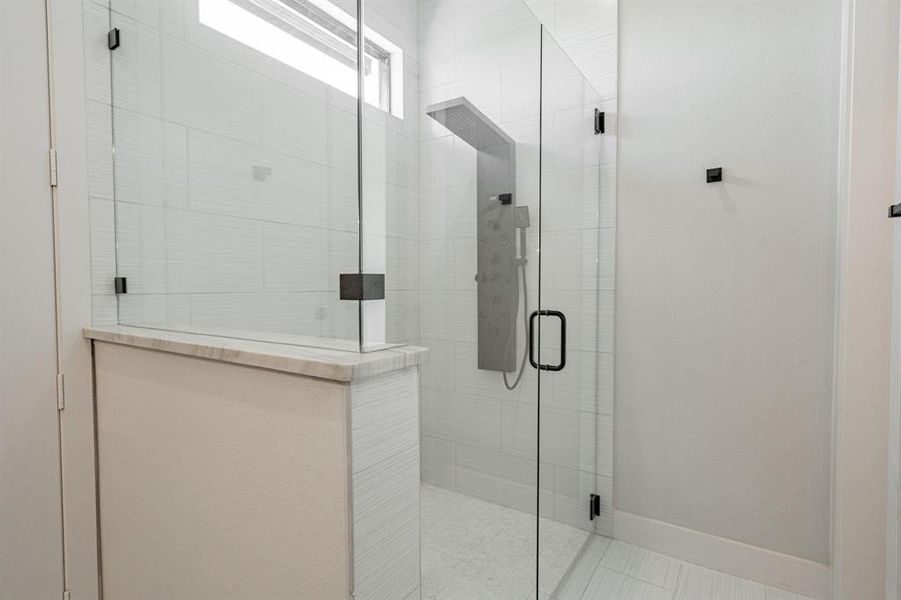 Example of builders Bathroom featuring tile patterned floors and an enclosed shower