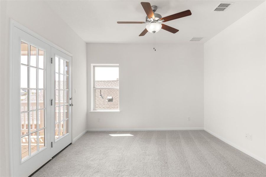 Carpeted spare room featuring baseboards, ceiling fan, and visible vents