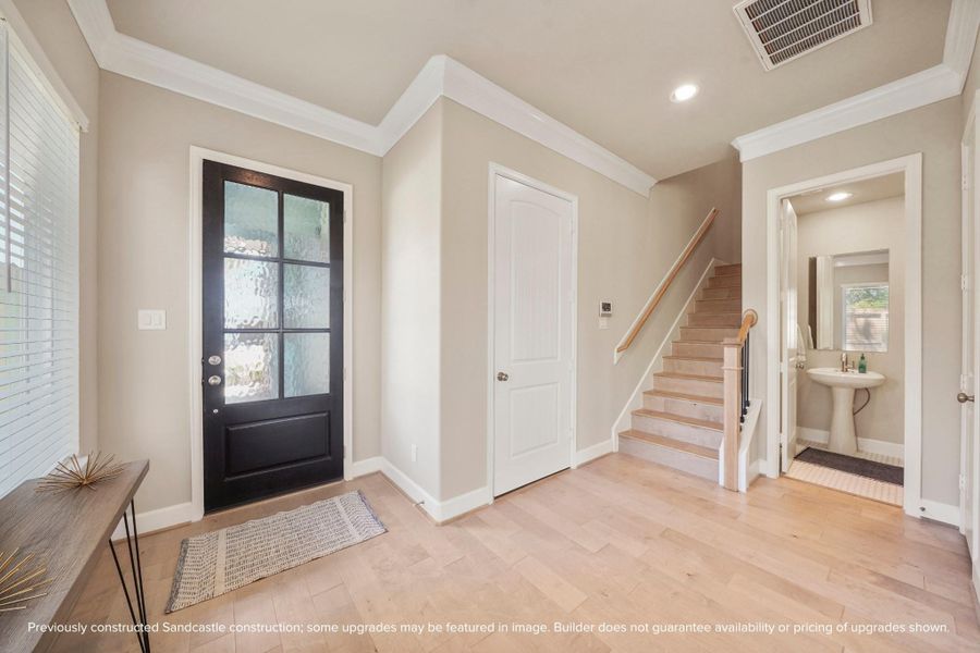 A warm welcome with thoughtful touches — crown molding, natural light, and a perfectly placed powder bath for guests.