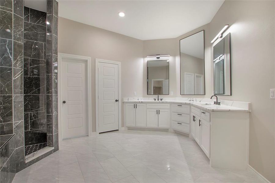 Bathroom with vanity and tiled shower