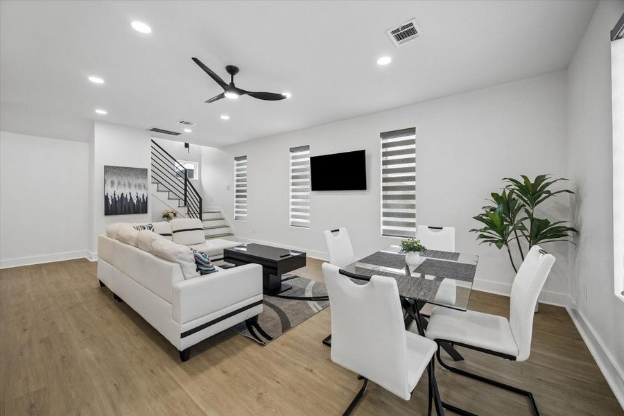 Black metal stair railing keeps sightlines open between living and dining. Table sits by the window wall, steps from the kitchen. Black metal stair railing keeps sightlines open between living and dining. Table sits by the window wall, steps from the kitchen.