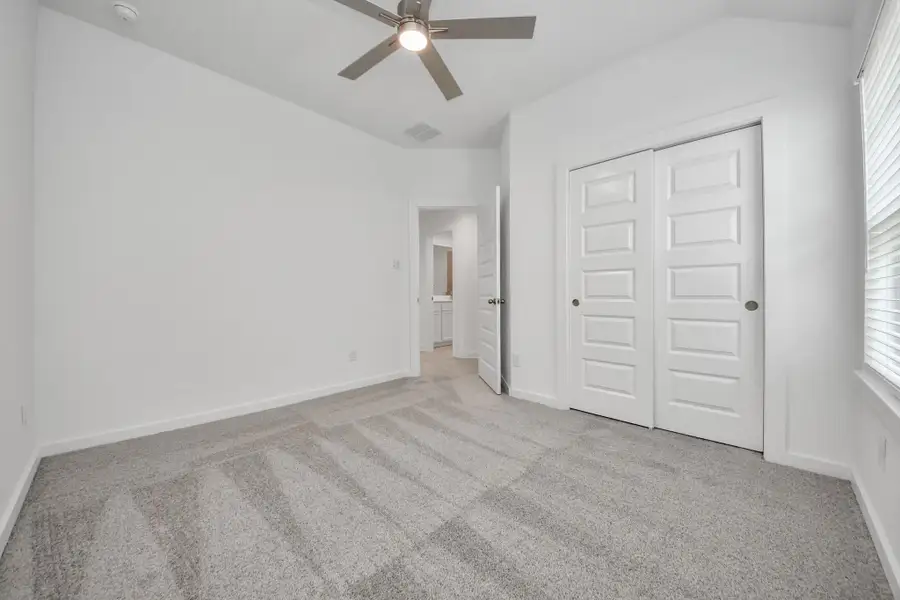 Generously sized secondary bedrooms featuring spacious closets, soft and inviting carpeting underfoot, large windows allowing plenty of natural light, and the added touch of privacy blinds for your personal retreat. Sample photo of completed home with similar floor plan. Actual colors and selections may vary.