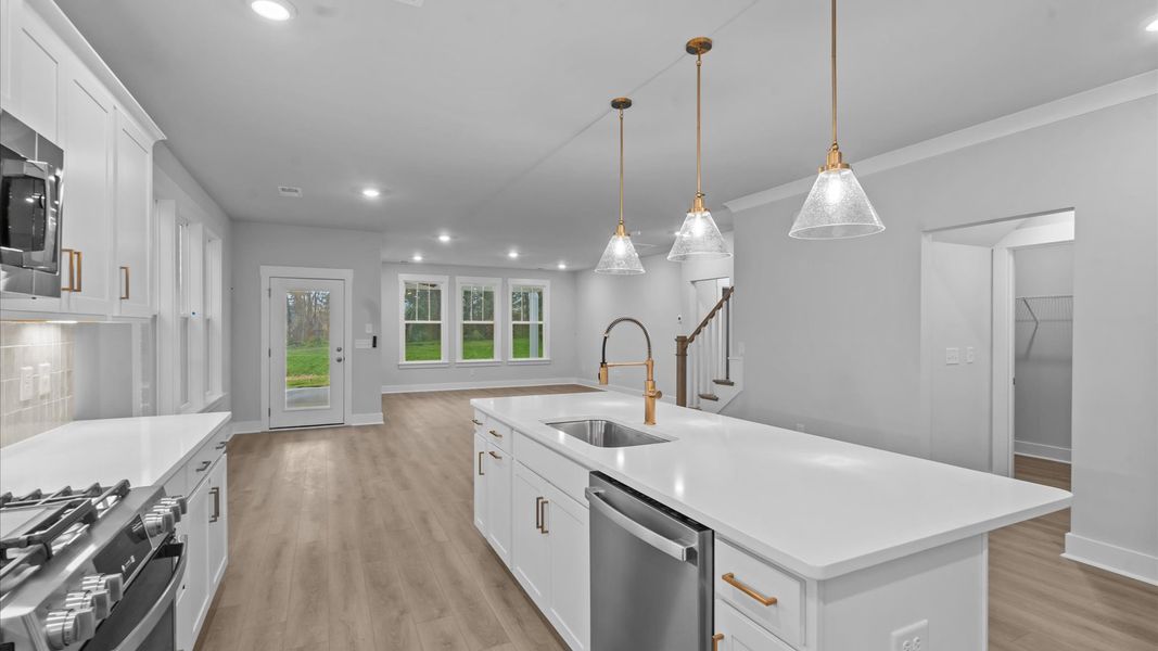 Highly skilled kitchen design includes a 9-foot island, quartz countertops, and stylish pendant fixtures Highly skilled kitchen design includes a 9-foot island, quartz countertops, and stylish pendant fixtures