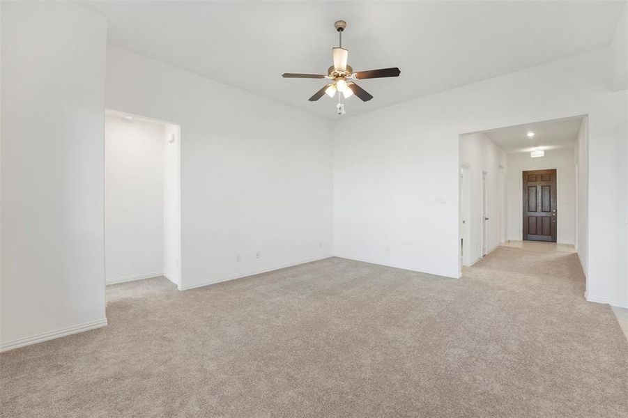 Carpeted empty room with ceiling fan