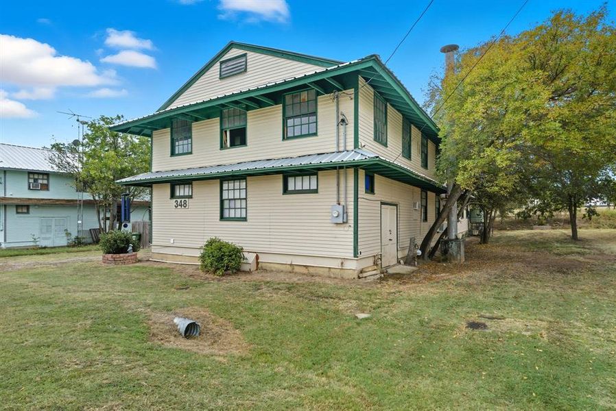 Rear view of house with a lawn and a metal roof Rear view of house with a lawn and a metal roof