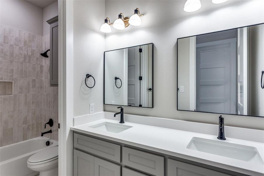 Full bathroom featuring double vanity and shower / washtub combination Full bathroom featuring double vanity and shower / washtub combination