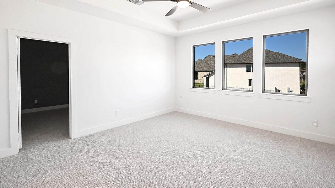 Unfurnished room with light colored carpet and a ceiling fan Unfurnished room with light colored carpet and a ceiling fan