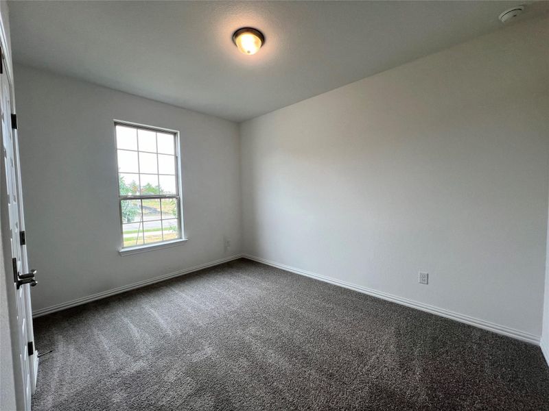 Unfurnished room with a smoke detector and dark colored carpet Unfurnished room with a smoke detector and dark colored carpet