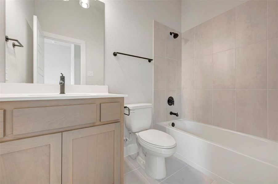 Bathroom featuring a light wood-finish vanity with a white countertop and dark bronze fixtures