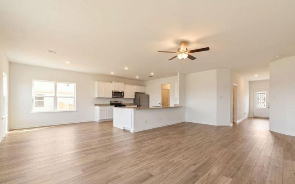An open-concept living space with sleek flooring and a contemporary kitchen area.