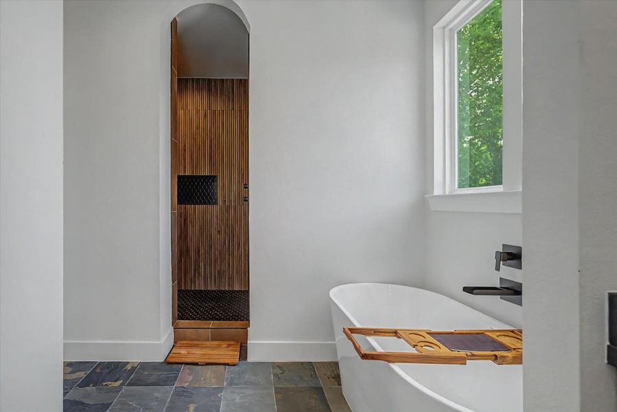 Spacious master bathroom featuring a deep soaking tub and an adjoining walk-in shower.