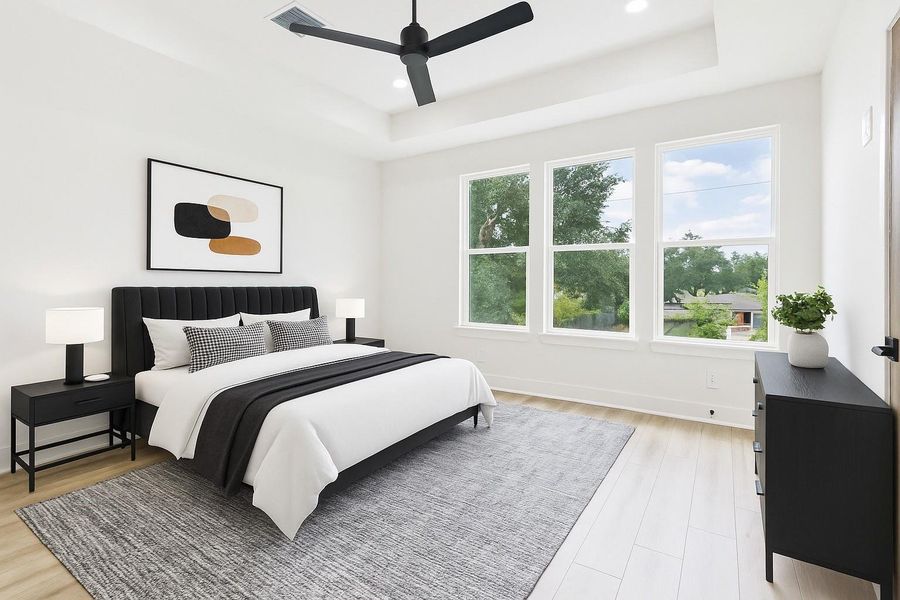 This bedroom is bright and modern, featuring large windows with a scenic view, a sleek ceiling fan, and minimalist decor. It includes a comfortable bed, stylish nightstands, and a cozy area rug on light wood flooring.  This photo Is AI staged.