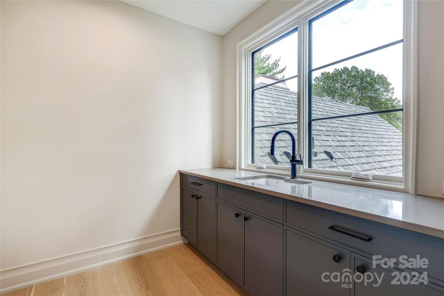 Upstairs Laundry Room with sink and cabinetry