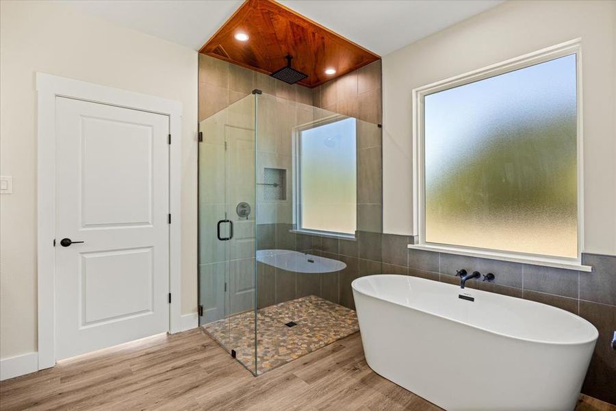 Full bathroom with a soaking tub, a stall shower with teak wood