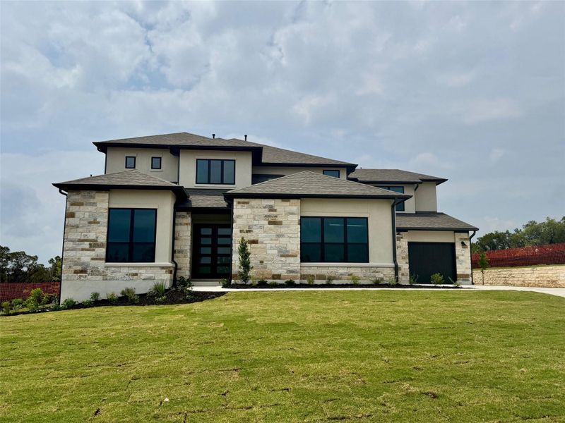 Front exterior of a new home in The Hollows Sanctuary - 85', Jonestown, TX, highlighting curb appeal (Image 1). Front exterior of a new home in The Hollows Sanctuary - 85', Jonestown, TX, highlighting curb appeal (Image 1).