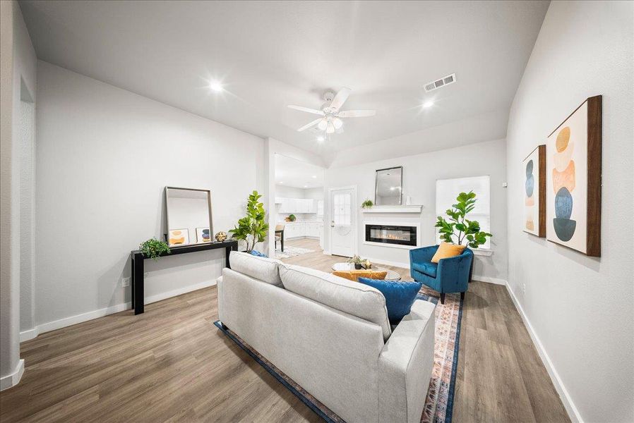 Living area featuring a glass covered fireplace, wood finished floors, recessed lighting, and ceiling fan Living area featuring a glass covered fireplace, wood finished floors, recessed lighting, and ceiling fan