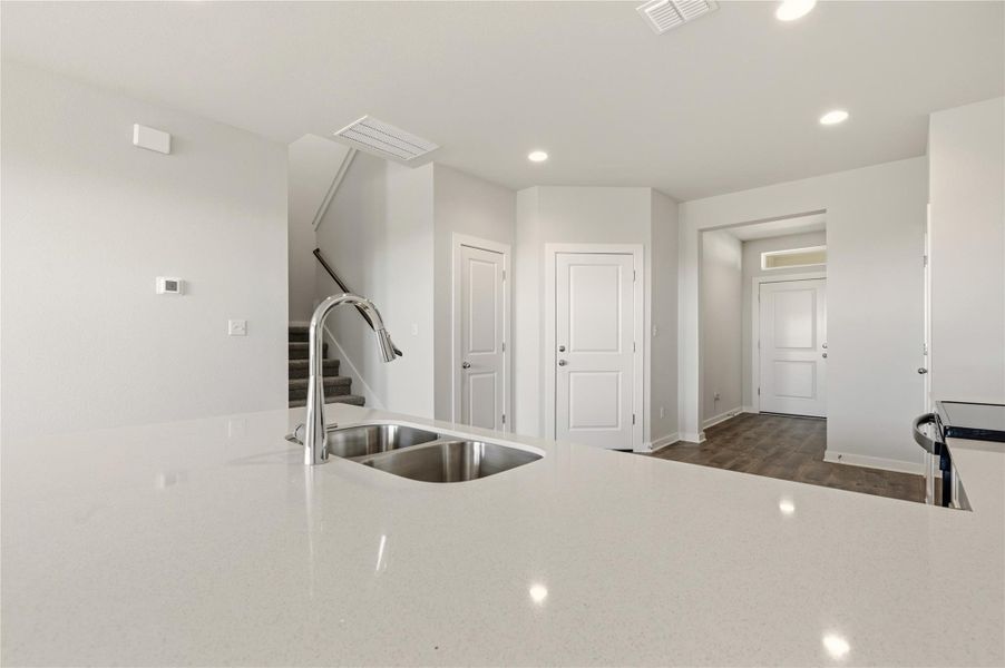 Kitchen featuring recessed lighting, black range with electric stovetop, light stone countertops, and dark wood finished floors