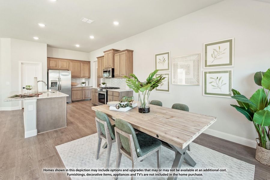 Open dining area with wood table and green chairs, connected to kitchen with tan cabinets and stainless appliances Open dining area with wood table and green chairs, connected to kitchen with tan cabinets and stainless appliances